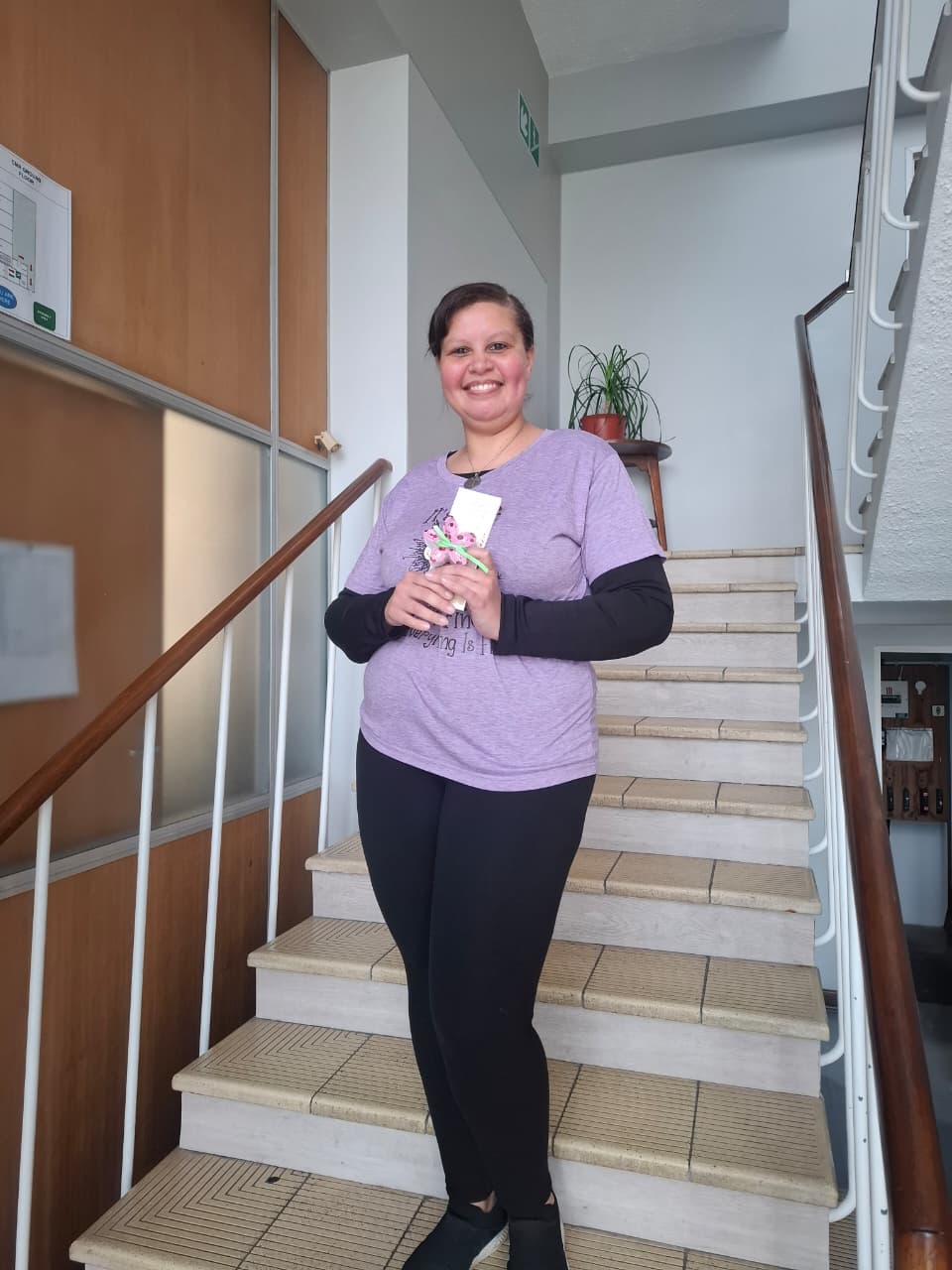 A member of the administrative team holding her Women's Day gift and thank-you card.