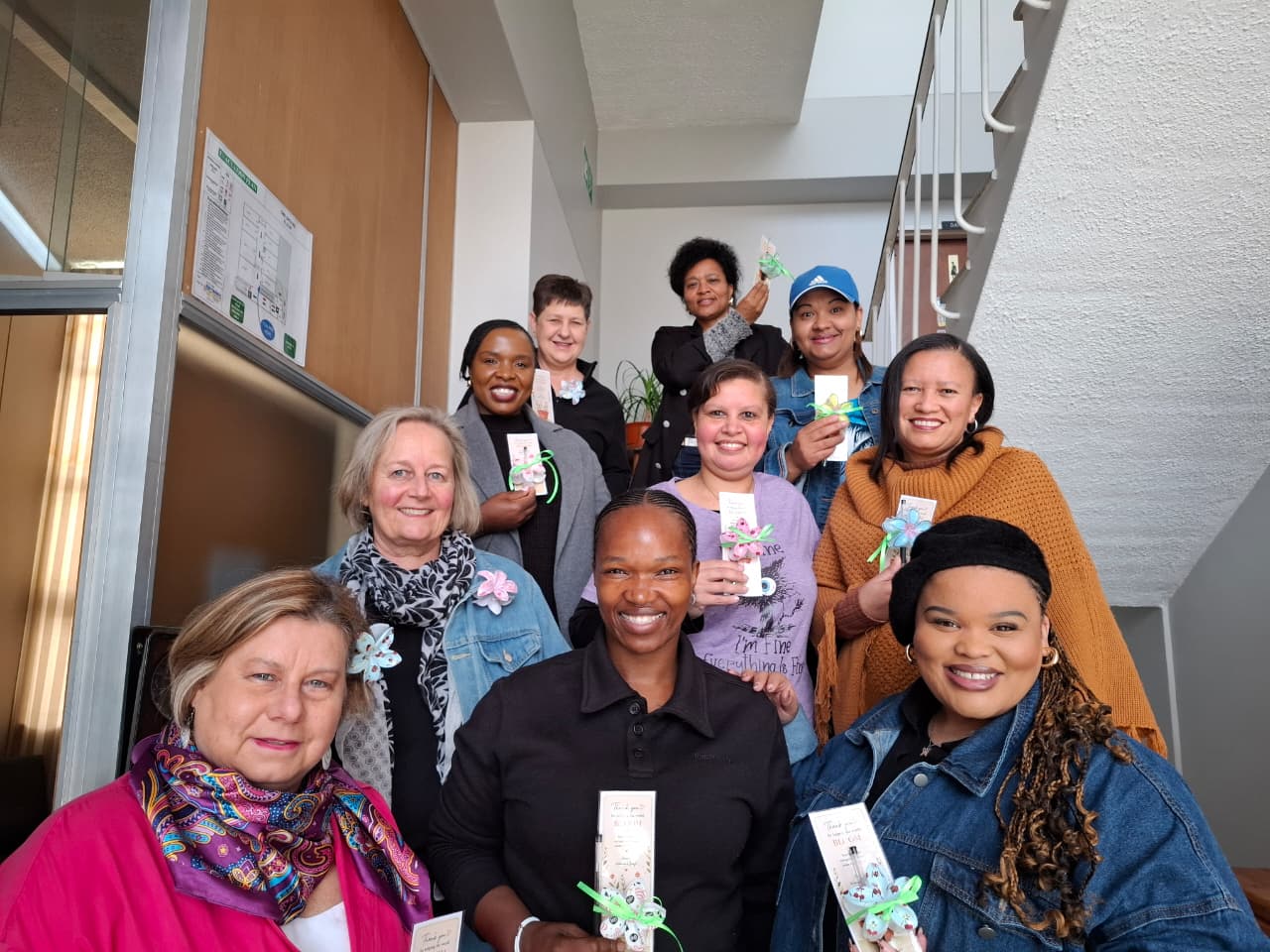 The Where We Bloom team gathered together on the stairwell to celebrate Women's Day.